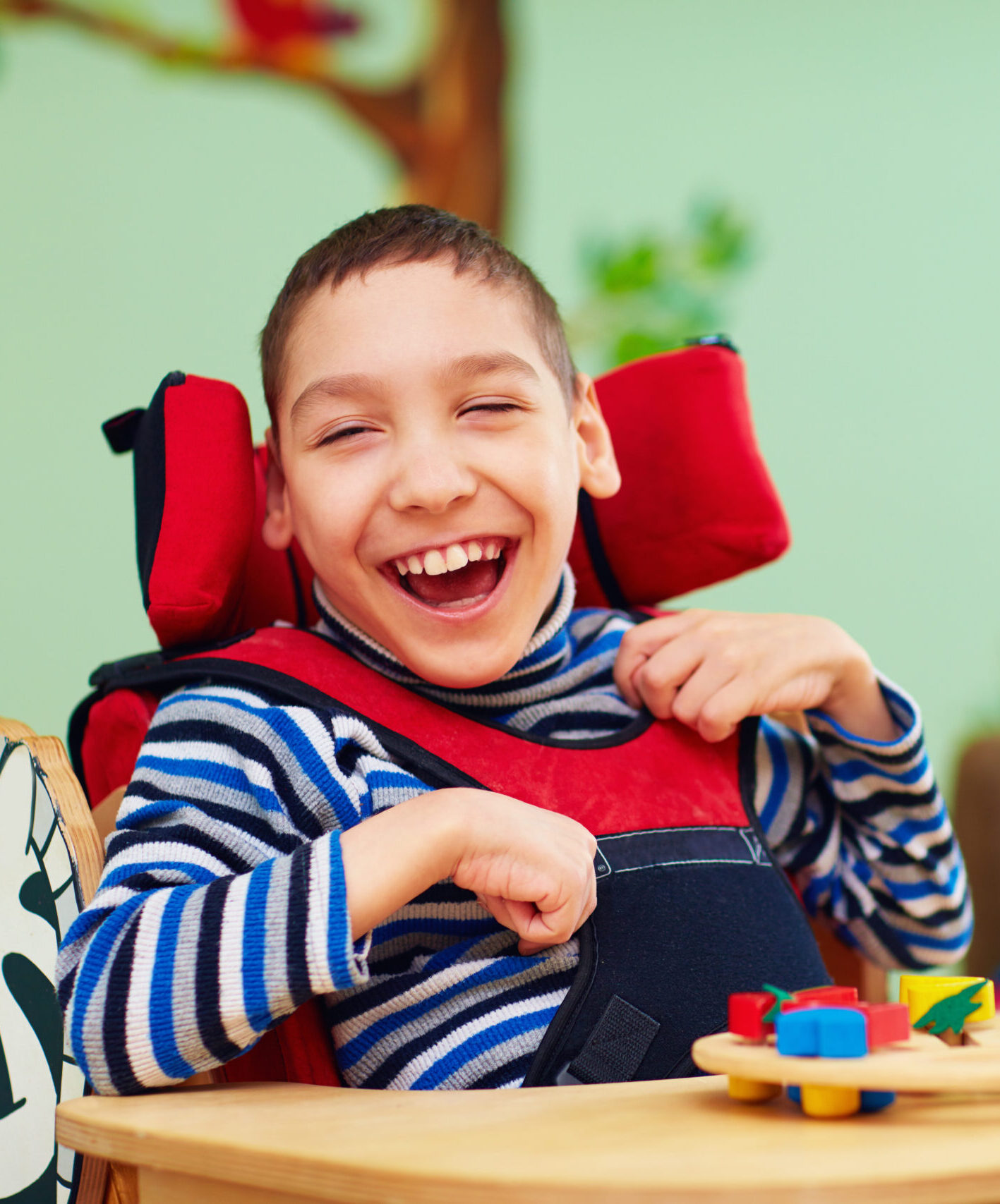 cheerful boy with disability at rehabilitation center for kids with special needs