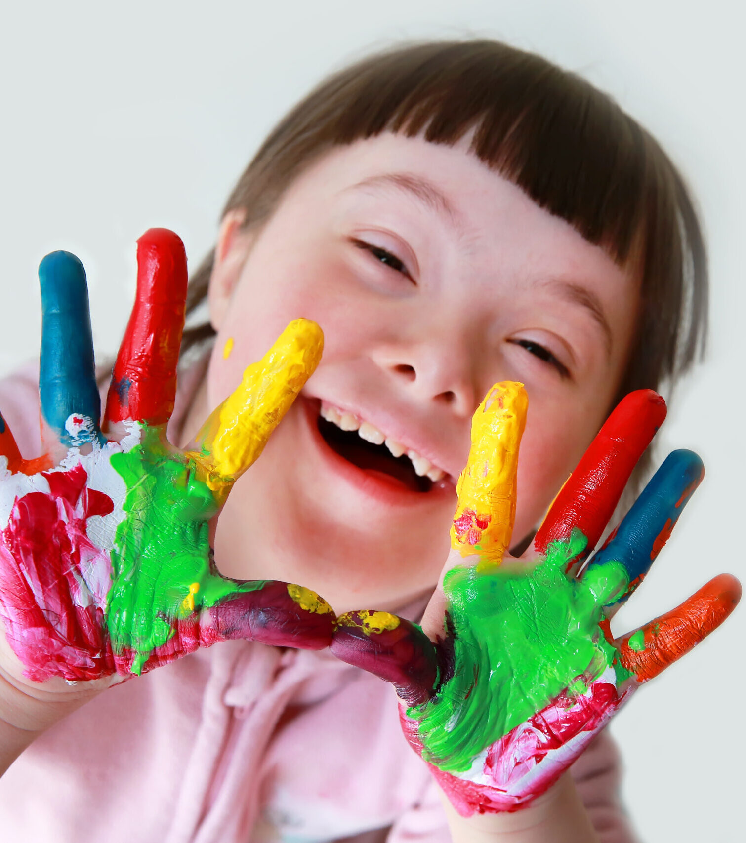 Cute little down syndrome girl with painted hands.