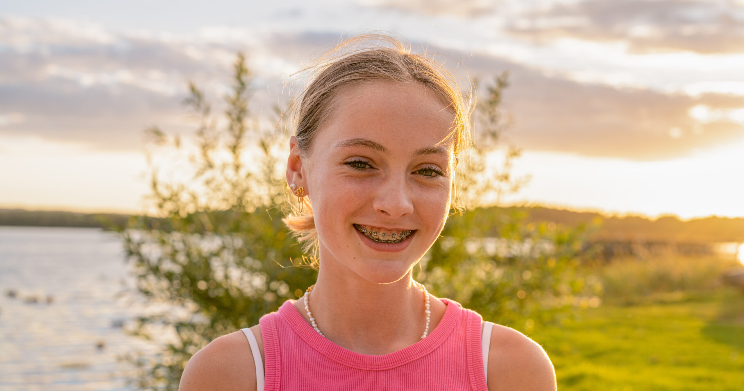 Portrait of a happy smiling teen girl with dental braces in a park.