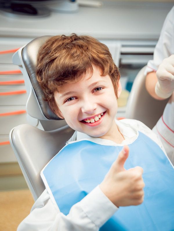 kid thumbs ups while smiling
