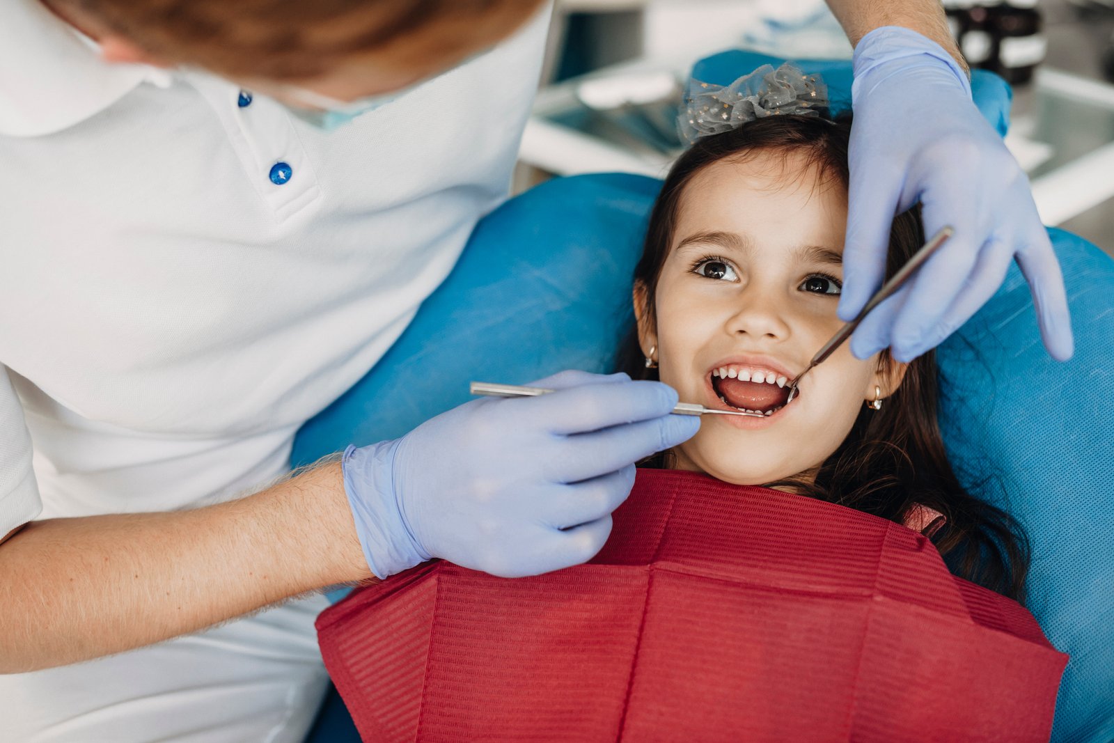 Pediatric dentist checking a child’s teeth for a space maintainer evaluation